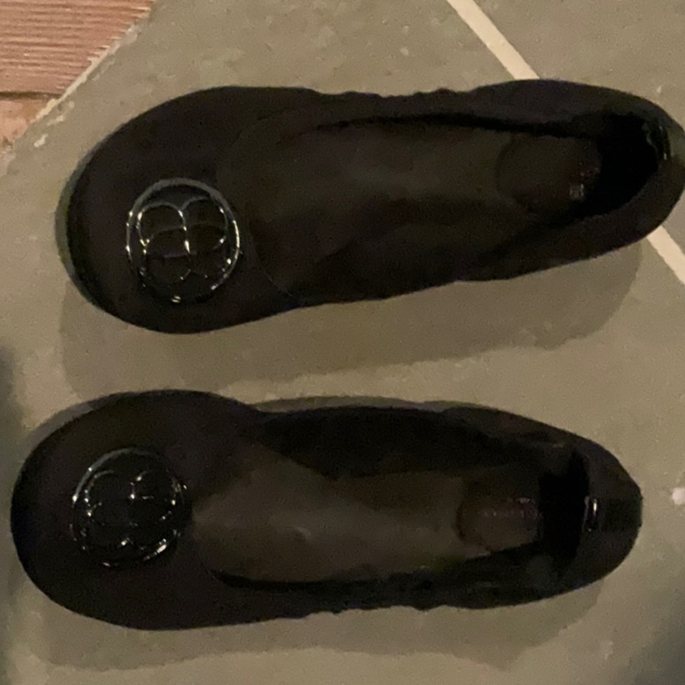 Black flats with medallion on toes.